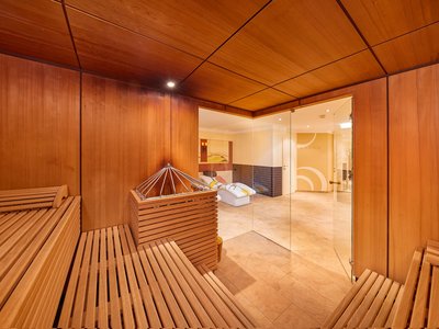 Wellnesshotel in Sölden: Hotel Sunny Innenansicht einer Holzsauna mit Glasfront zu einem Ruhebereich