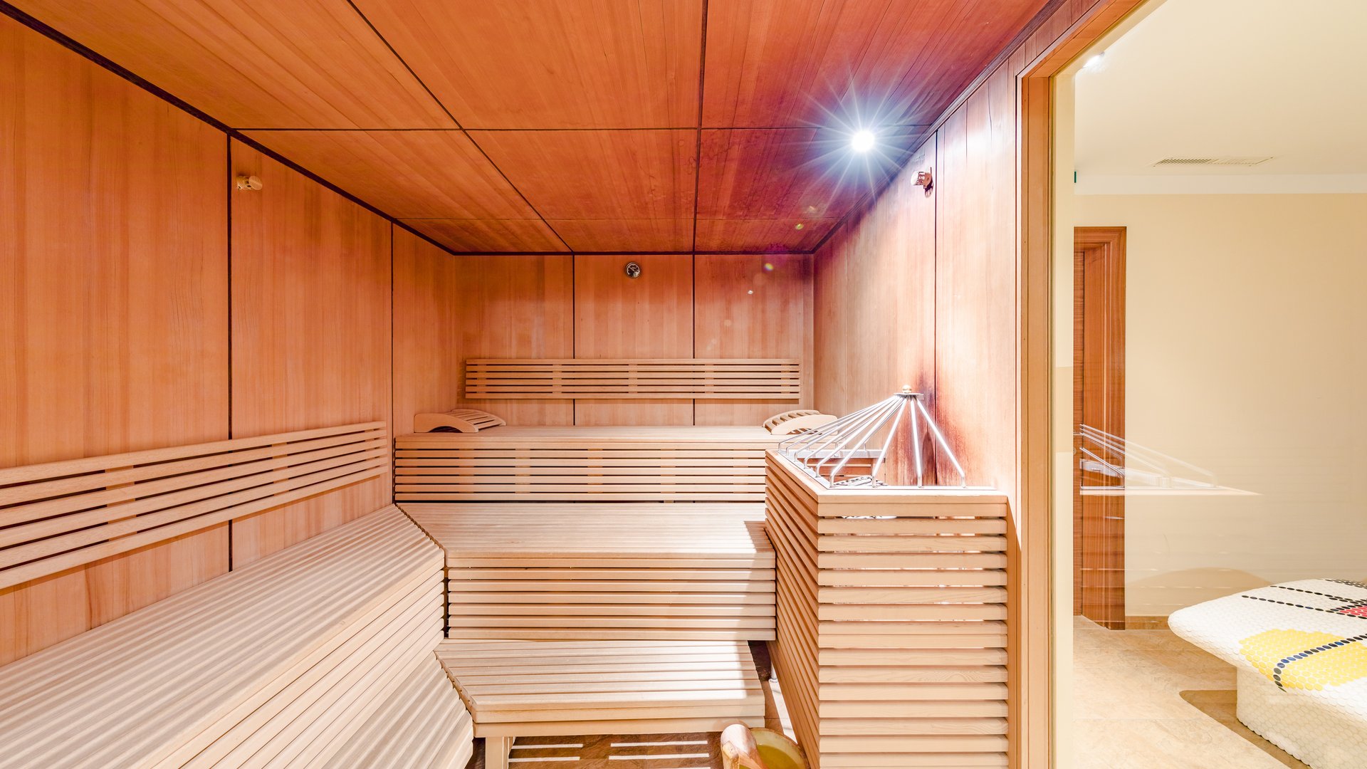 Wellnesshotel in Sölden: Hotel Sunny Helle Holzsauna mit Sitzbänken, Saunaofen und angrenzendem Ruheraum