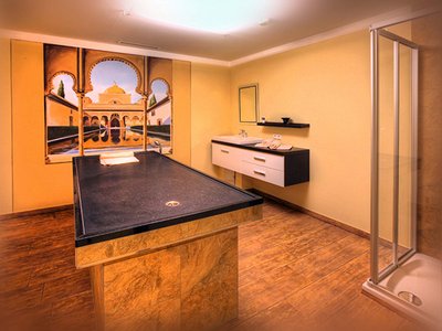 Wellness hotel in Sölden: Hotel Sunny Wellness room with massage table, shower, and oriental wall art