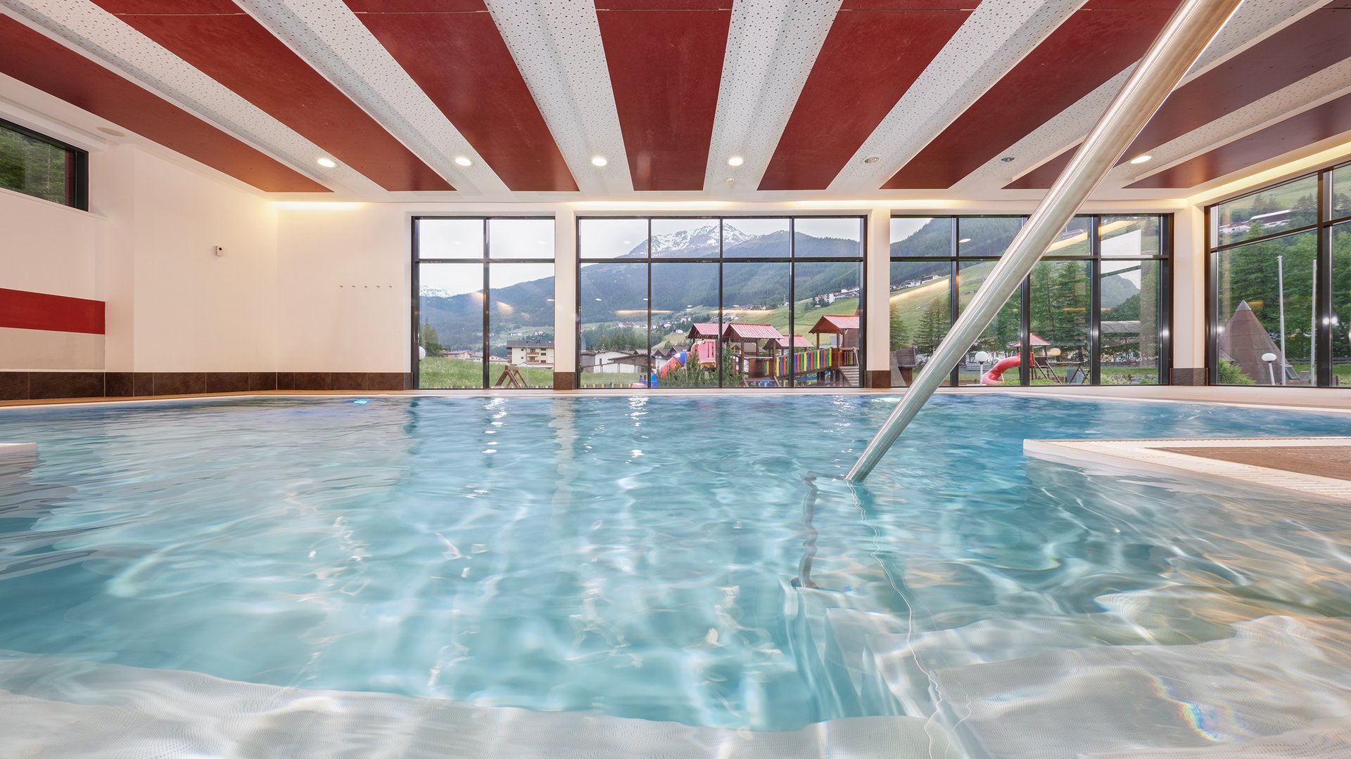 Dein 4-Sterne-Hotel in Sölden Hallenbad mit Bergblick und buntem Spielplatz durch große Fenster
