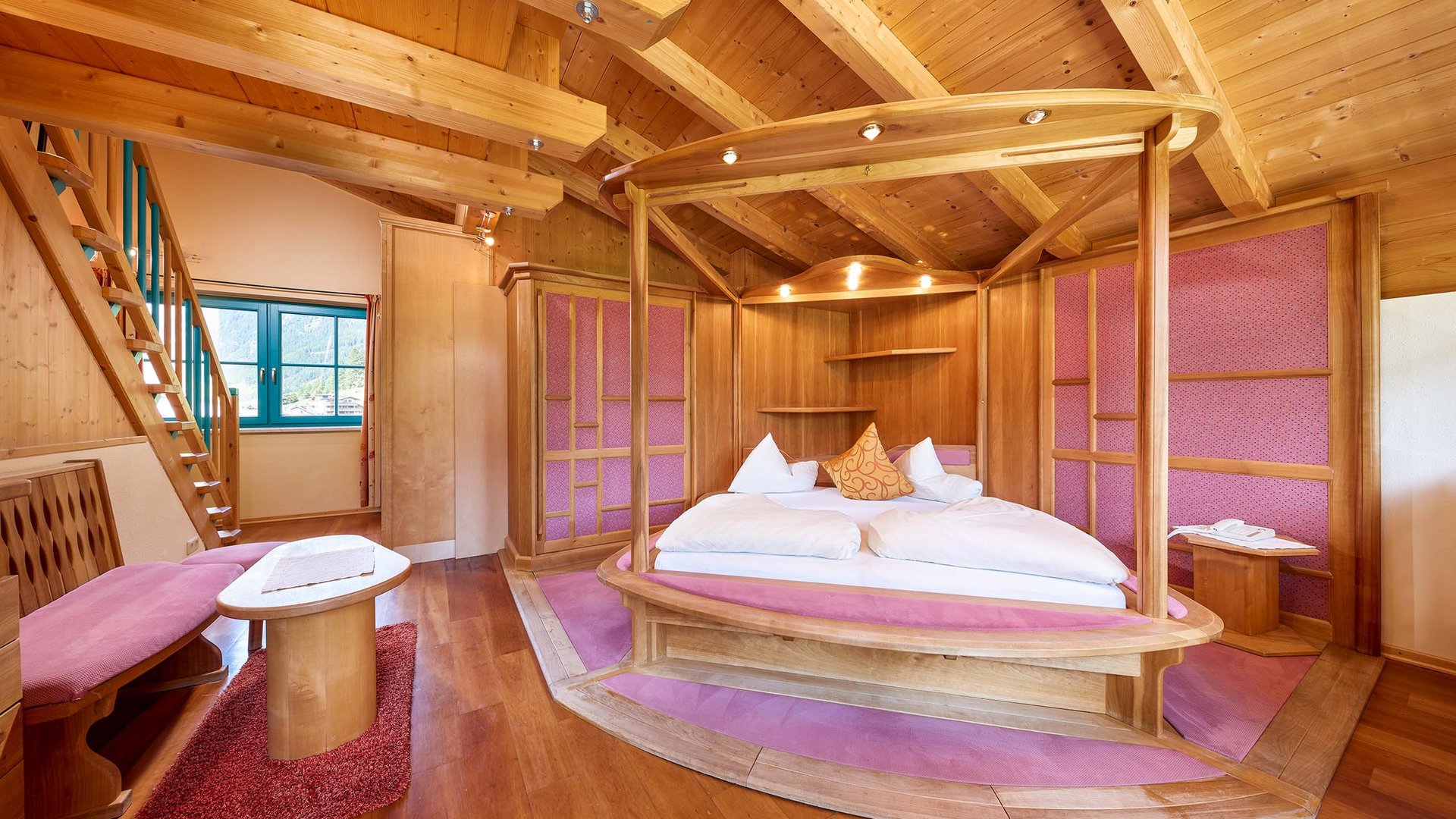 Hotel in Ötztal: restful sleep Cozy bedroom with wooden ceiling and round canopy bed with pink accents